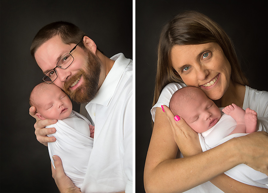 st-louis-newborn-photographer-mom-and-dad-in-white-holing-baby-boy-on-black-backdrop.jpg