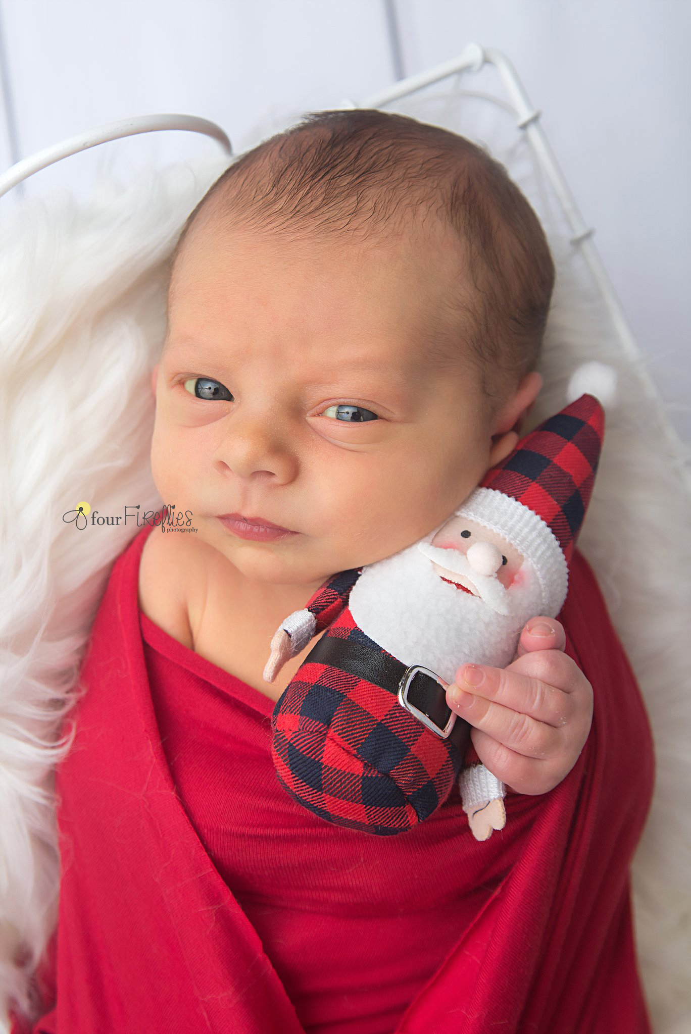 st-louis-newborn-photographer-christmas-baby-awake-holding-buffalo-plaid-stuffed-santa.jpg
