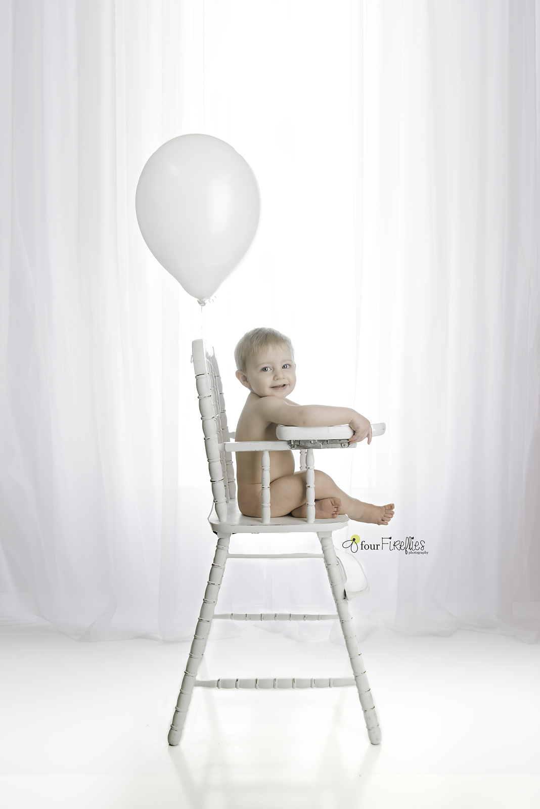 st-louis-photography-studio-first-birthday-baby-boy-in-high-chair-with-balloon-all-white-simple.jpg