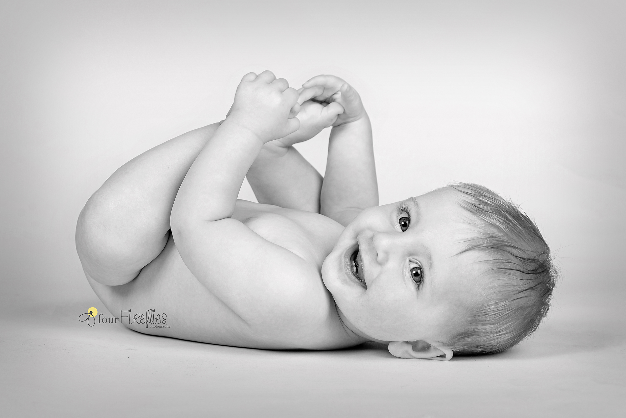 st-louis-photography-studio-six-month-milestone-session-black-and-white-baby-boy-holding-feet.jpg