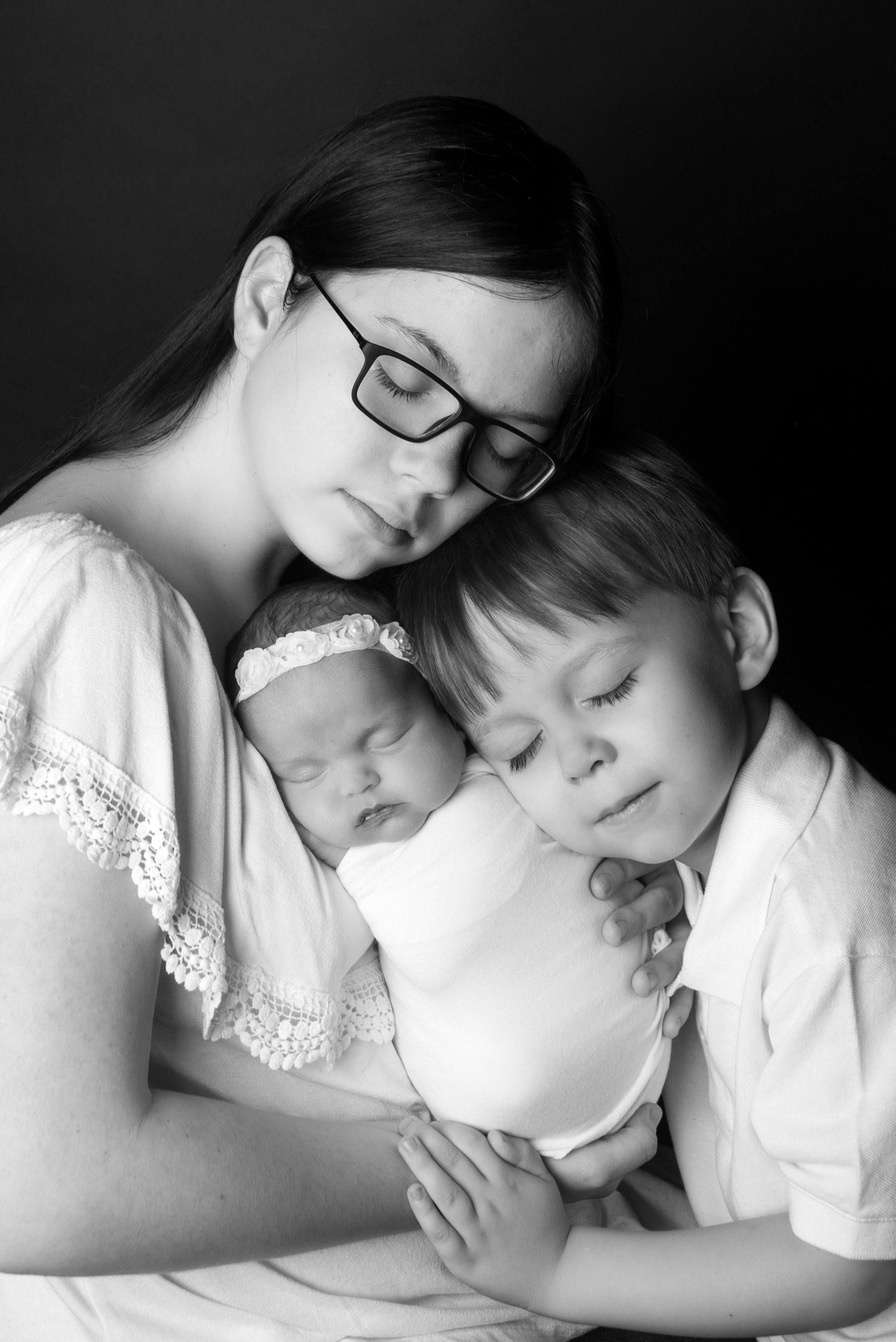 st-louis-newborn-photographer-black-and-white-picture-of-baby-girl-with-big-brother-and-sister-eye-closed.jpg