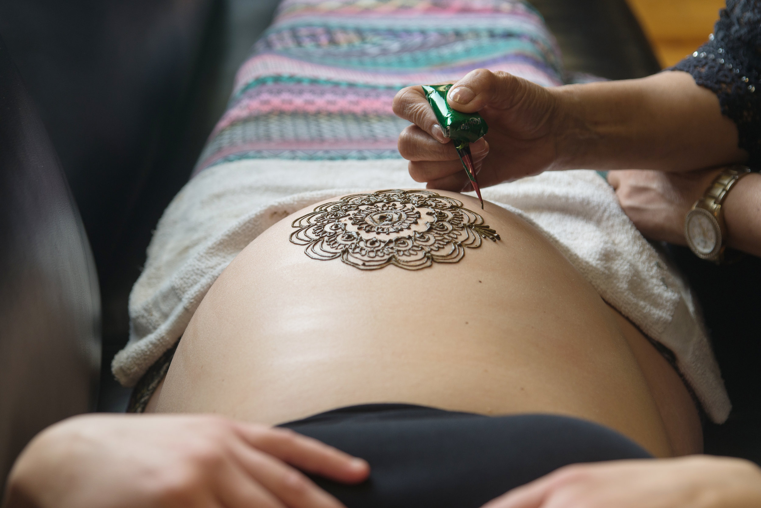st-louis-maternity-henna-photography-close-up-of-henna-being-applied-to-belly.jpg