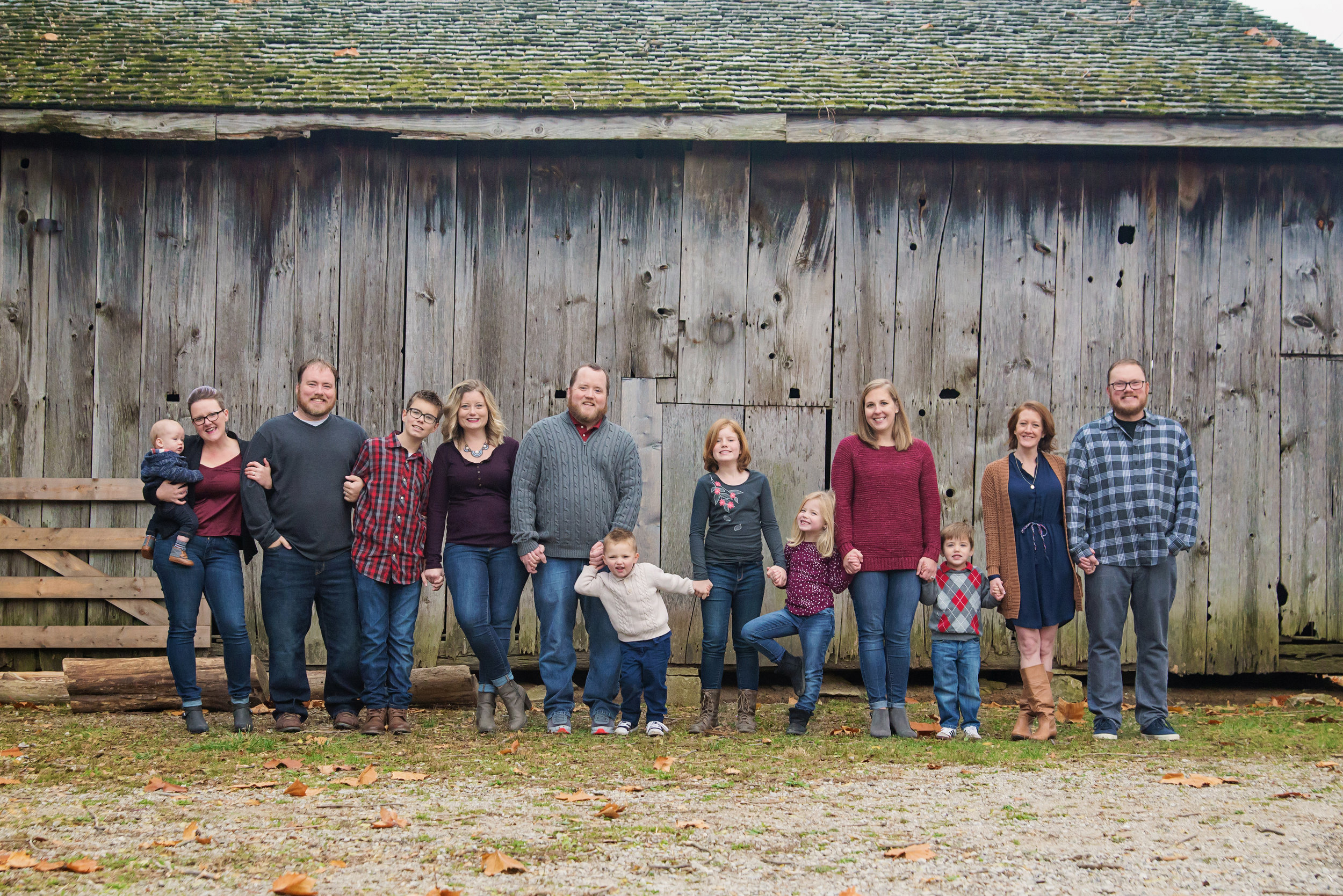 st-louis-family-photogrpaher-extended-family-session-family-standing-along-barn-at-faust-park.jpg