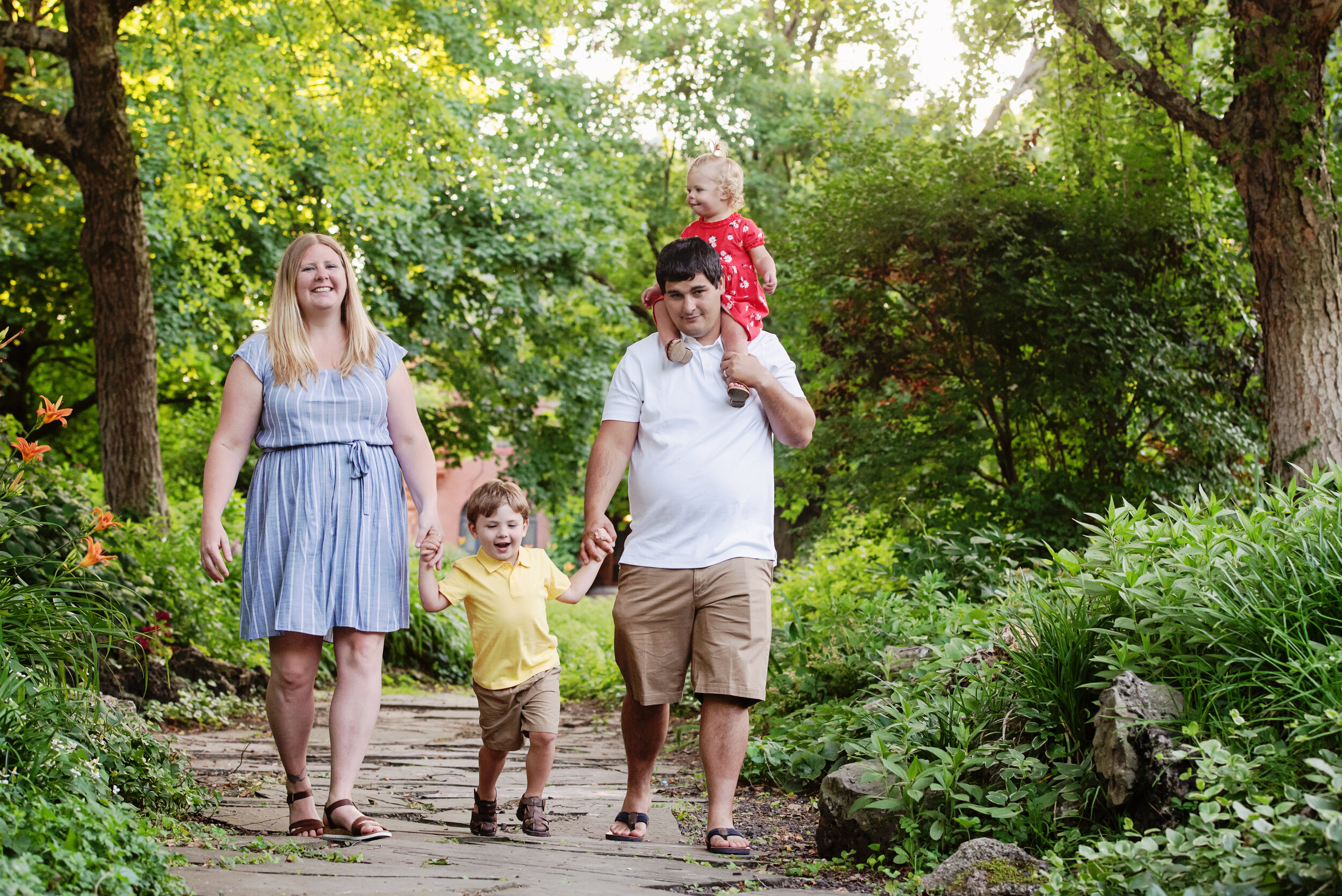 st-louis-family-photographer-spring-mini-sessions-2021-family-of-four-in-colorful-outfits-walking-along-path-at-lafayette-park-st-louis.jpg