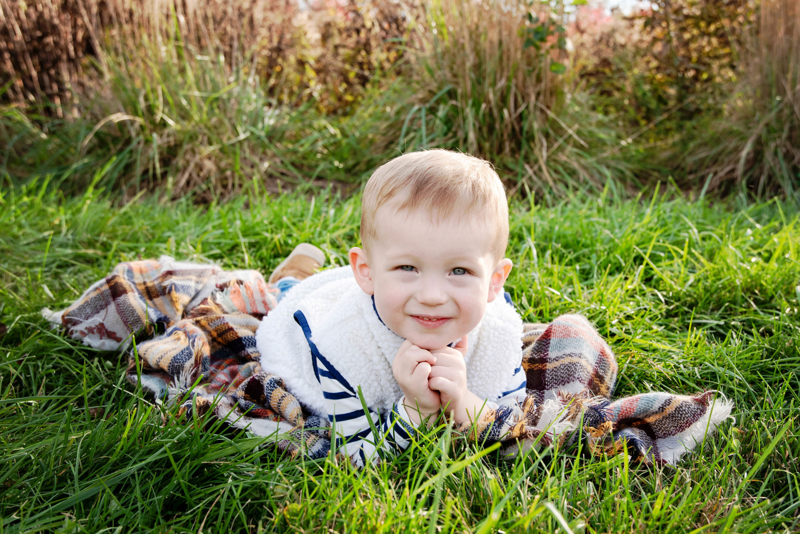 St-Louis-Fall-Mini-Sessions-little-boy-in-grass-with-fall-color-blanket-at-forest-park